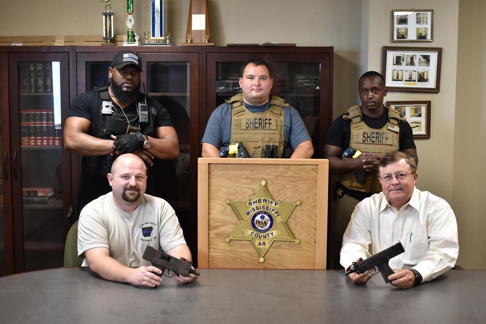 Image of Sheriff and deputies with confiscated guns. 