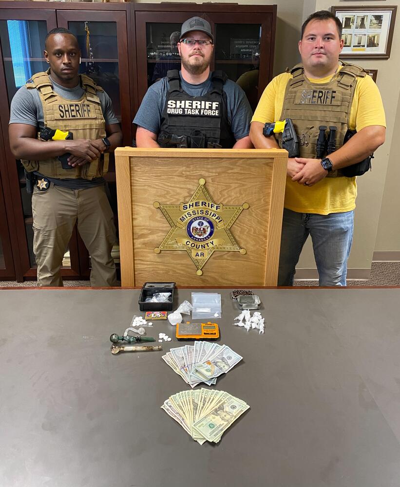 Photo of staff with seized drugs.
