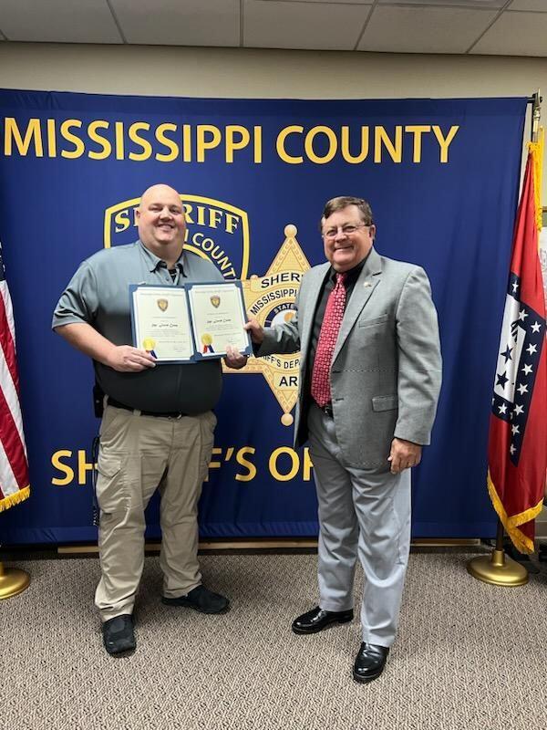 Sergeant Camp posing for photo with Sheriff Cook. 