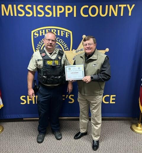 Cpl. Danner and Sheriff Cook holding an award certificate.