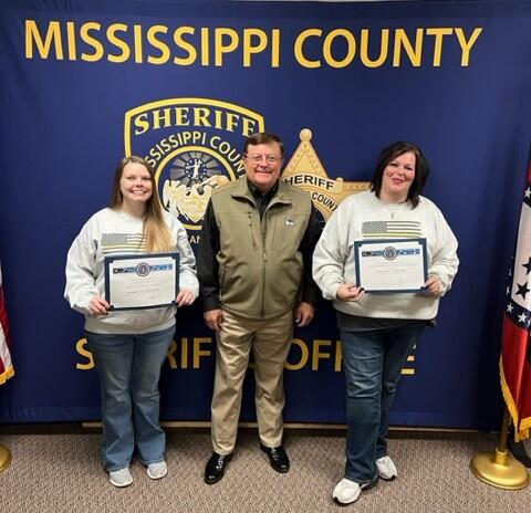 Sheriff Cook holding awards with two dispatchers.