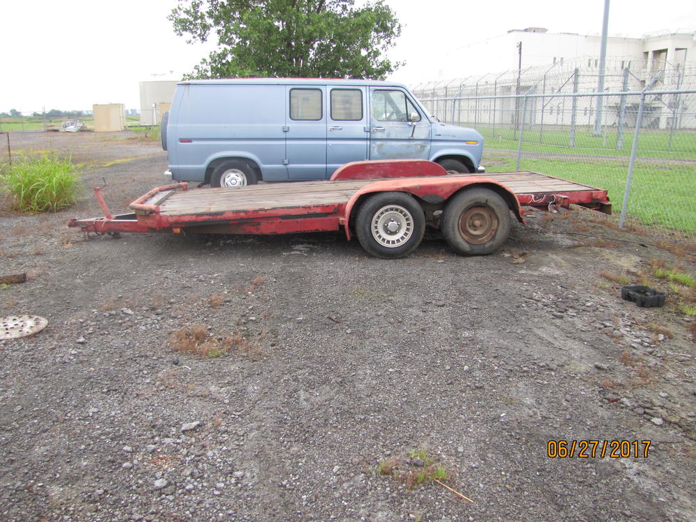 Side view of a red flat bed trailer.