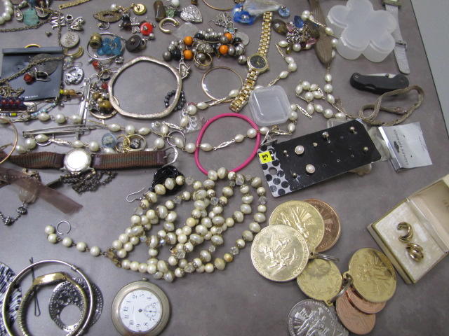 Several large gold colored coins and beaded necklaces.