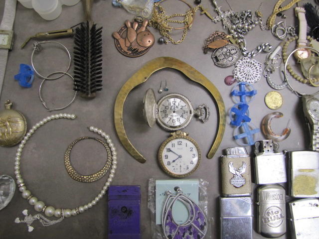 Two pocket watches and several lighters that are silver in color.