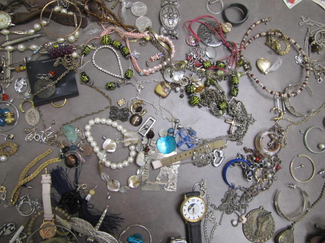 Several pieces of silver in color necklaces and bracelets.