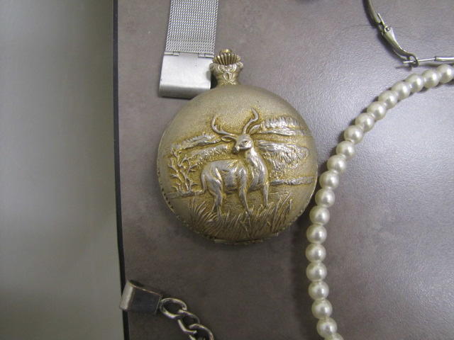 Photo of a gold pocket watch with a deer image. 