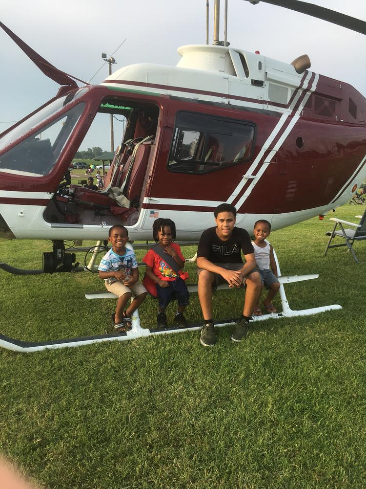 Photo of kids sitting on helicopter. 