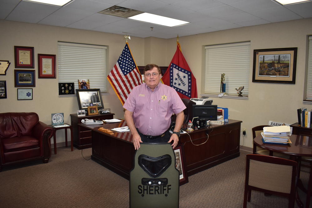 Image of Sheriff Cook holding shield. 